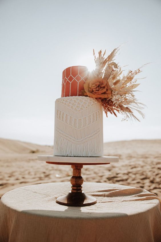02-a-boho-wedding-cake-with-a-rust-patterned-and-a-white-macrame-tier-with-dried-foliage-blooms-and-herbs-is-chic